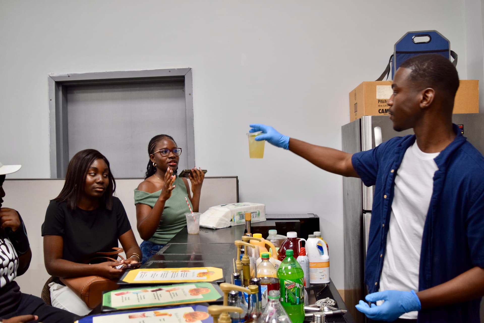 Nektar bartender serving a freshly poured mocktail to guests at an event